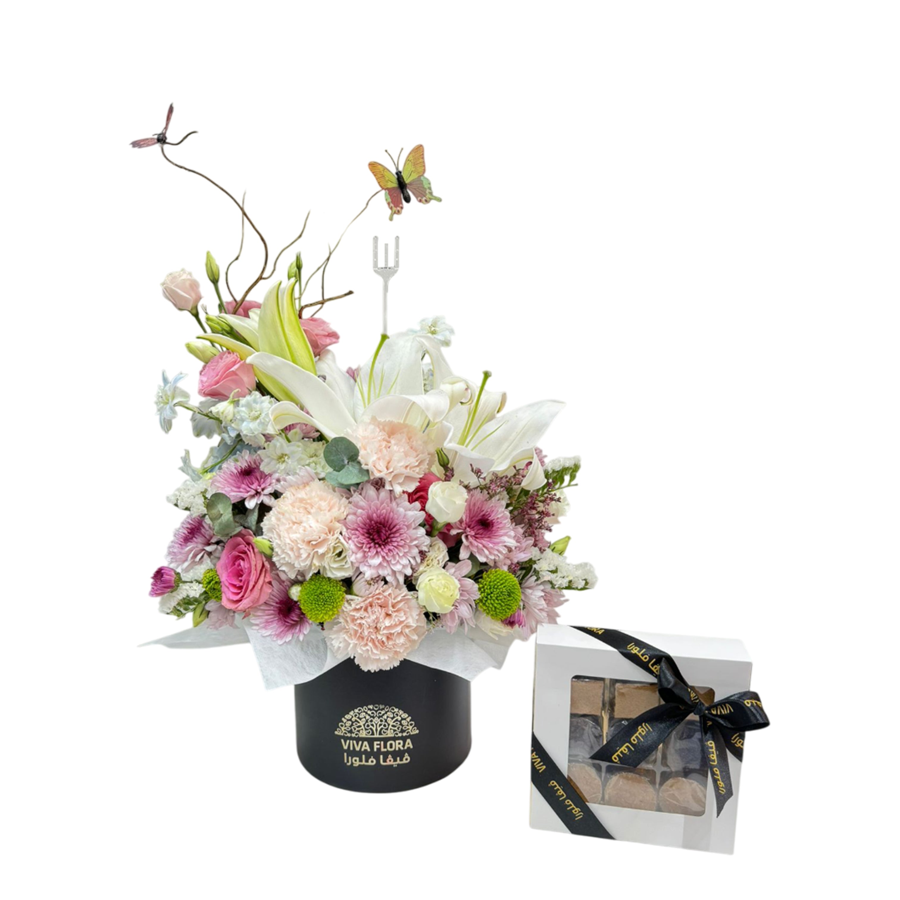 Elegant pastel flower arrangement in black Viva Flora box with a white chocolate gift box tied with ribbon, featuring lilies, roses, and daisies.