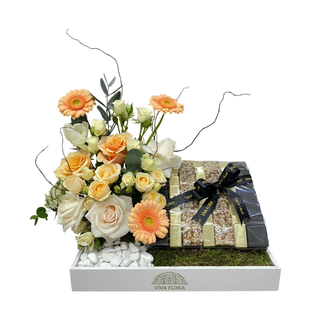 Luxury white tray with peach and white roses, gerberas, and 800g of assorted chocolates wrapped in Viva Flora ribbon.