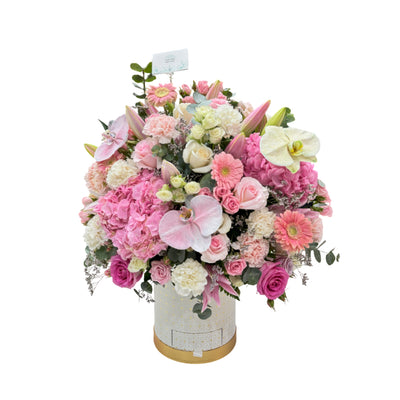 An opulent pink box with roses, hydrangeas, lilies, gerberas, and orchids.