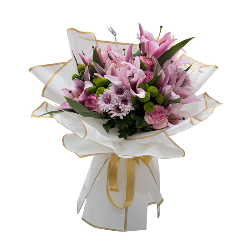 A beautiful bouquet of pink lilies, roses, and chrysanthemums wrapped in white paper with a gold ribbon.