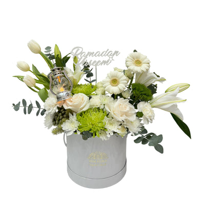 Elegant white Ramadan flower arrangement with lilies, roses, gerberas, greenery, and a decorative lantern in a chic white box.