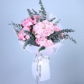 Heart-shaped box filled with red and white roses on a light surface.