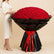 A large bouquet of red roses wrapped in black paper with a red ribbon bow, photographed on a clean white background.