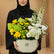 Floral arrangement with yellow and white flowers in a box, featuring 'Eid Mubarak' text on a light gray background.