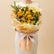 A vibrant bouquet of yellow and orange roses with green foliage, wrapped in peach-colored tissue paper and tied with a white ribbon, held by a person whose arm is visible on the left.