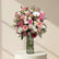A glass vase filled with a colorful bouquet of pink and white flowers.