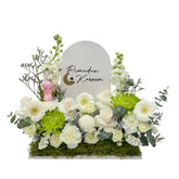 A floral display with white and green flowers, a "Ramadan Kareem" sign, and a small decorative lantern.