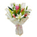 Bouquet of pink and white lilies wrapped in white and gold tied with a ribbon at the bottom placed on the table. 