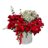 A white flower box with red roses, heart shaped gypso, eucalyptus accented by a butterfly.