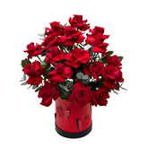 A red box accented with butterflies filled witth red roses and eucalyptus.