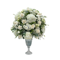 An elegant white bouquet of roses, hydrangeas, and chrysanthemums in a crystal vase.