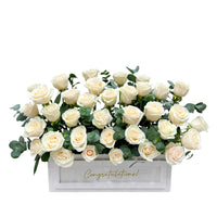 White roses in white rectangular box with “Congratulations” text.