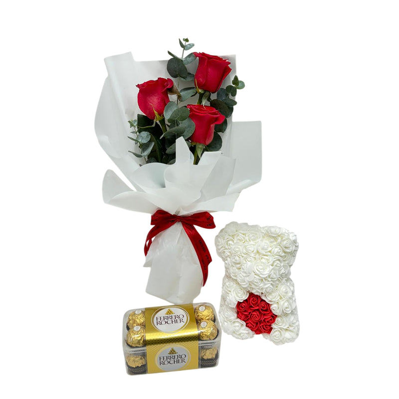 Perfect Valentine’s gift trio: red roses, Ferrero Rocher chocolates, and a white rose teddy bear arrangement.