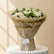 A large floral bouquet wrapped in beige paper and tied with a white ribbon, displayed indoors on a White Podium and badge colour background  