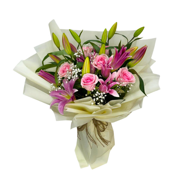 Pink lilies and roses, wrapped elegantly with greenery and delicate fillers in a bouquet