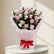 A bouquet of pink and white roses wrapped in light pink tissue paper with a red ribbon tied in a bow at the base, set against a light marble-patterned background.
