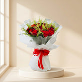 perfect hand bouquet with red roses and transparent wrapping in beige colour background  