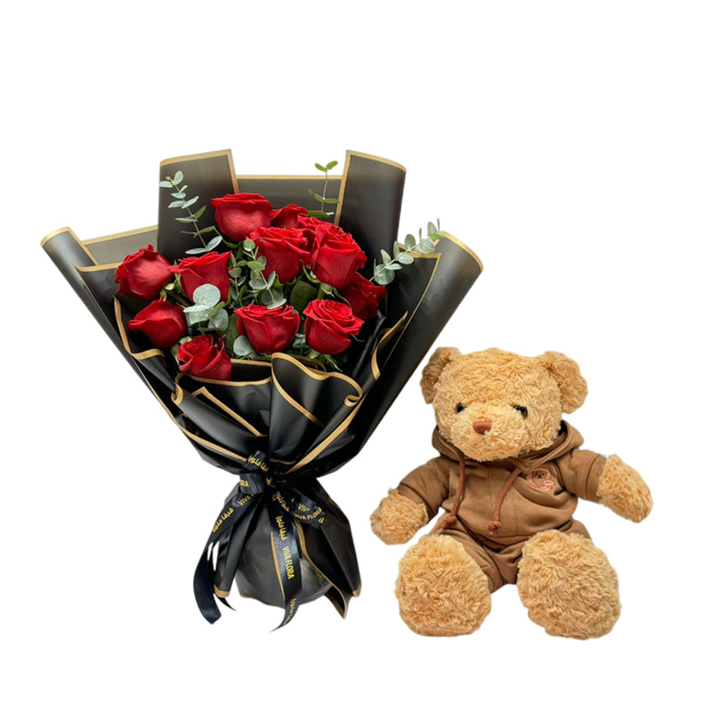 Red roses in a black wrapper with a teddy bear for romantic gifting