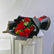A bouquet of 15 red roses wrapped in black paper with a red ribbon, displayed on a white cabinet against a light gray wall.