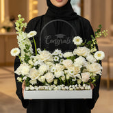 Floral arrangement with 'Congrats!' sign on a light gray background