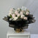 Blush and white roses bouquet wrapped in black paper with baby’s breath