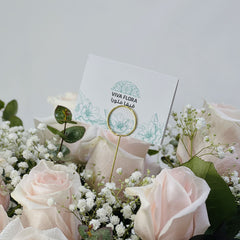 Blush and white roses bouquet wrapped in black paper with baby’s breath