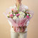 A vibrant floral bouquet wrapped in pink tissue paper and tied with a brown twine bow, displayed on a white pedestal against a light gray background.