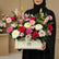 A vibrant floral arrangement in a cream-colored rectangular box on a white pedestal, featuring pink, red, white, and green flowers with a gold 'Happy Birthday' sign, from the brand VIVA FLORA.