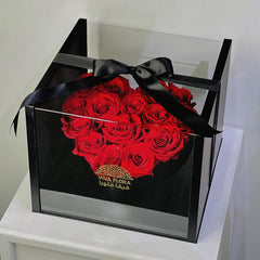 Heart-shaped arrangement of red roses in a clear box with a black ribbon, branded 'Viva Flora' perfect gift for your loved once in qatar