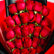 A bouquet of red roses wrapped in bright red and black paper, held by a hand against a light marble background.