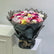 Colorful mixed flower bouquet with roses and chrysanthemums in black wrapping