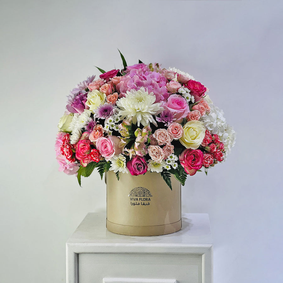 Luxury flower arrangement in a round box with mixed pastel roses and chrysanthemums
