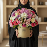 Colorful flower arrangement in a beige box with 'VIVA FLORE' branding on a white surface.
