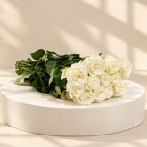 white roses bunch in a beige color podium 