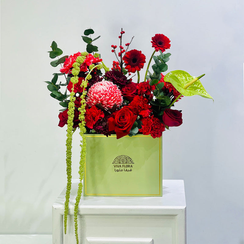 Colorful floral arrangement in a green box with 'VIVA FLORA Qatar' branding on a white surface. place your order now and make your loved once day more memorable in qatar