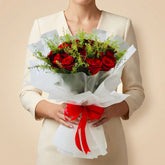 a lady holding a red roses bouquet in beige colour background