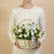 A white rose and eustoma flower basket in a woven wicker basket, tied with a white ribbon printed with the name 'VIVA EBRA', displayed on a white surface against a light gray background.