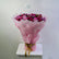 A bouquet of pink and magenta roses wrapped in light pink tissue paper and tied with a gold ribbon, displayed on a white pedestal against a plain light gray wall.