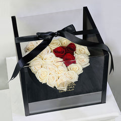 Heart-shaped arrangement of white and red roses in a clear box with a black ribbon, branded 'Viva Flora Qatar' best flower shop in qatar with same day delivery.